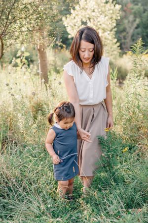 A candid outdoor photo showing tender interaction in a sunlit field with wildflowers.