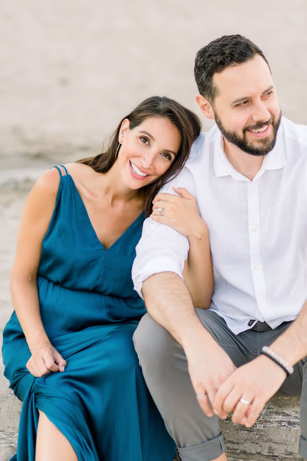 Couple sitting together with woman in blue dress and man in white shirt.