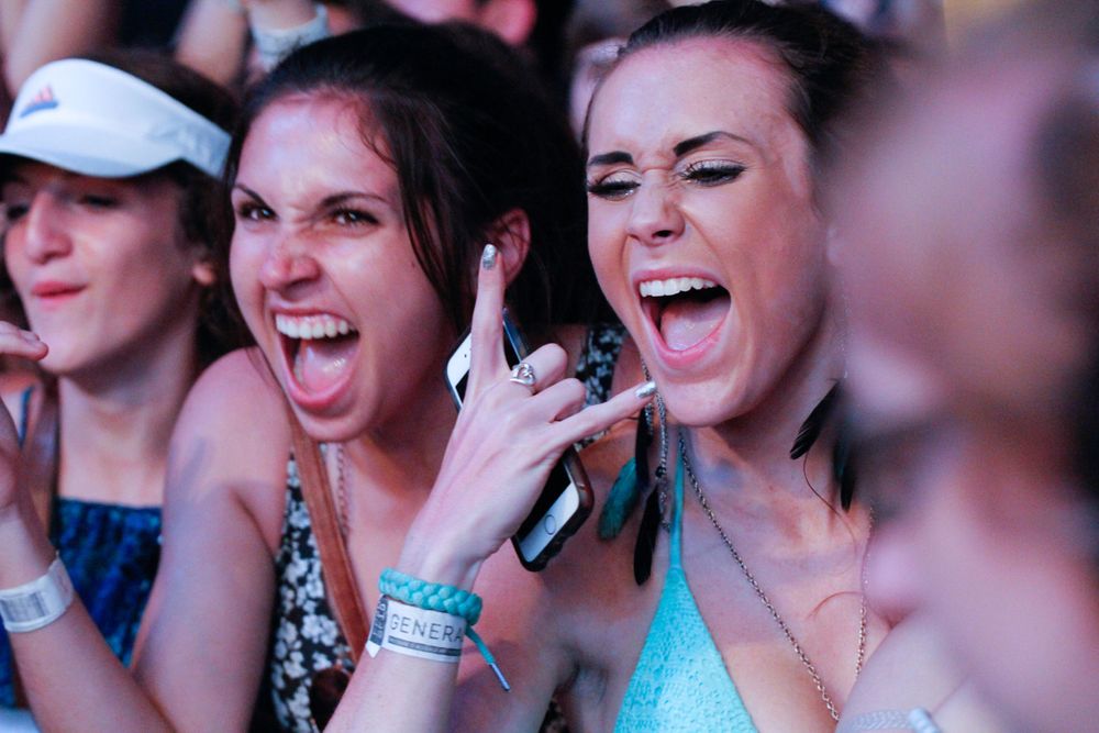 Concert attendees show excitement and emotion while watching a performance at a live music event.