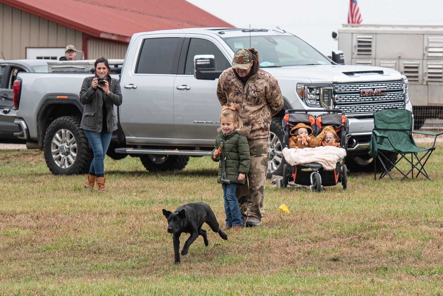 A little girl watches a Labrador puppy in action at a hunting retriever test near Greenwood, South Carolina.