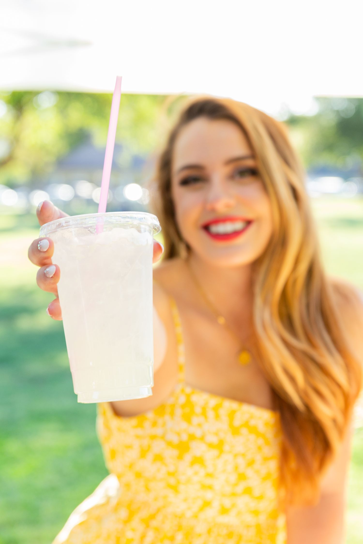 woman handing camera a glass of lemonade