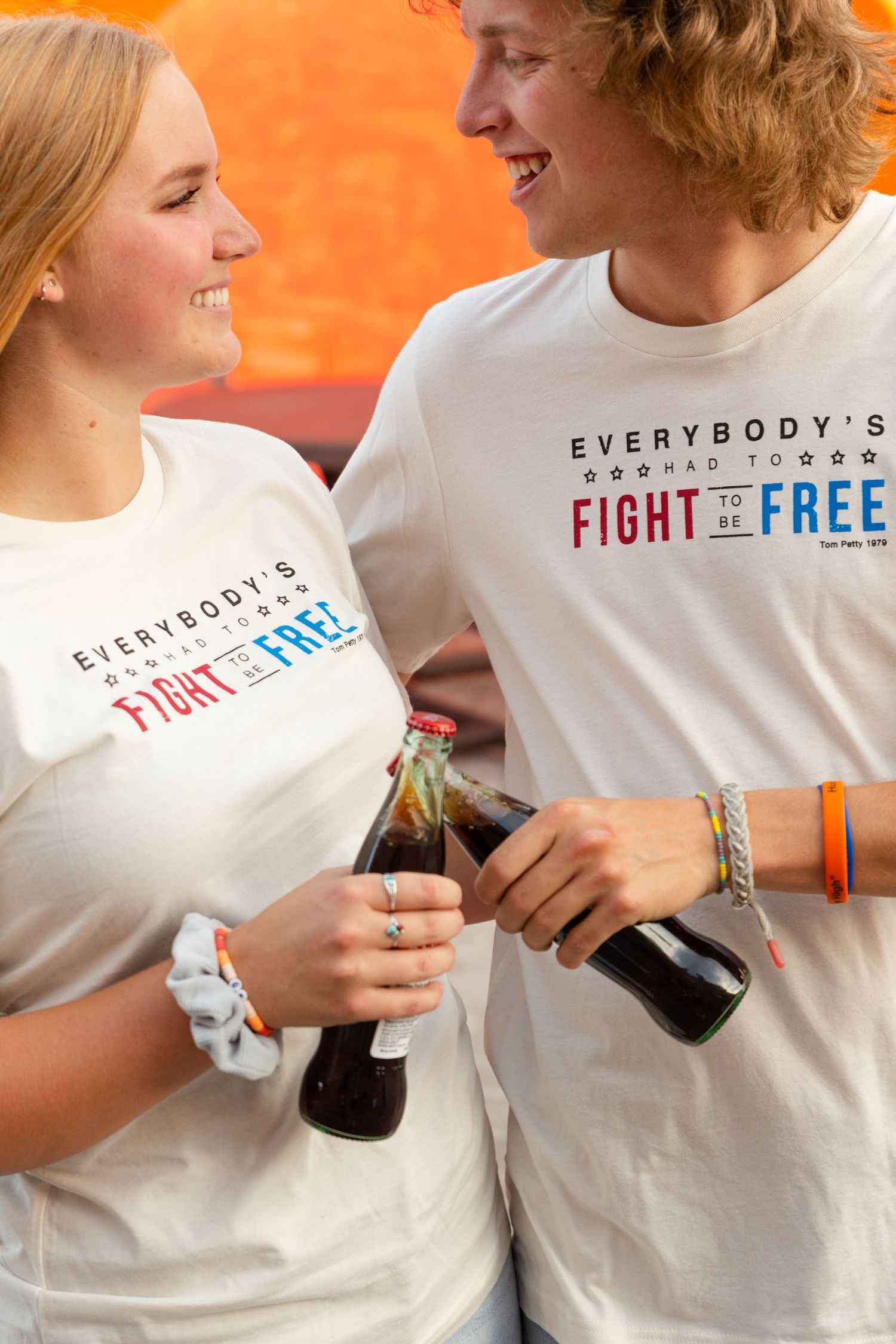 a man and woman cheersing soda wearing white fight for freedom t-shirts st George Utah