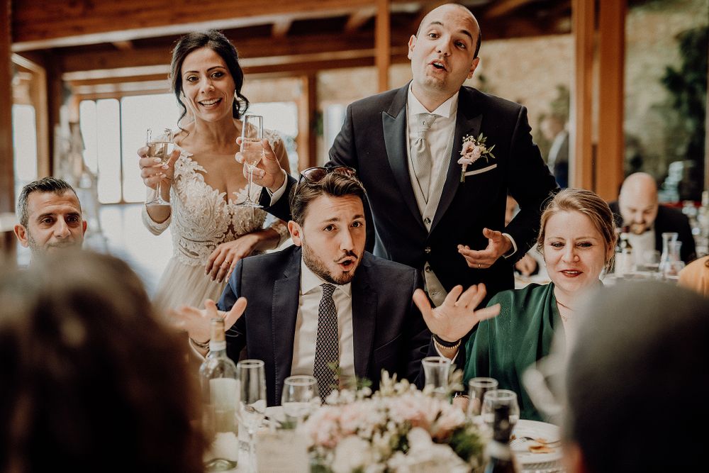 Bride and groom entertain surprised wedding guests with lively performance at reception dinner.