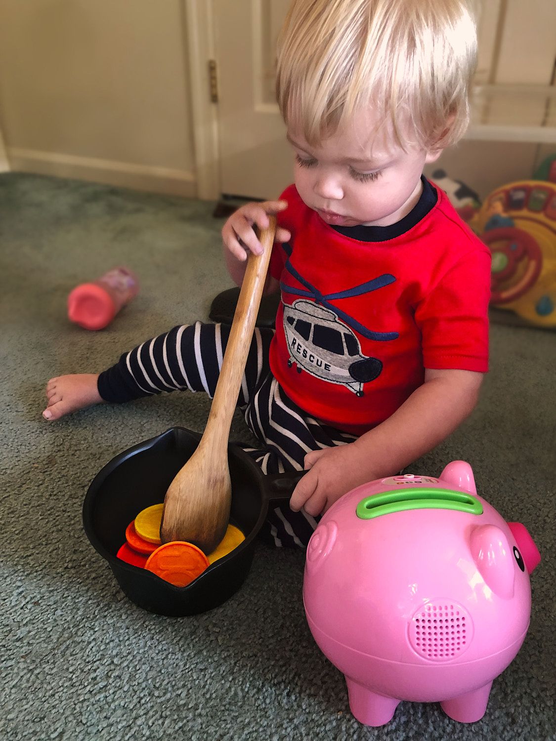 Toddler boy stirring pot of pretend food