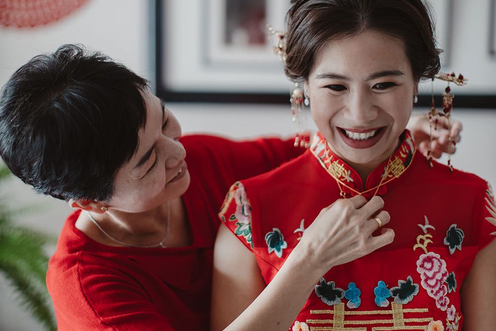 elder putting on necklace on a chinese bride in a wedding tea ceremony