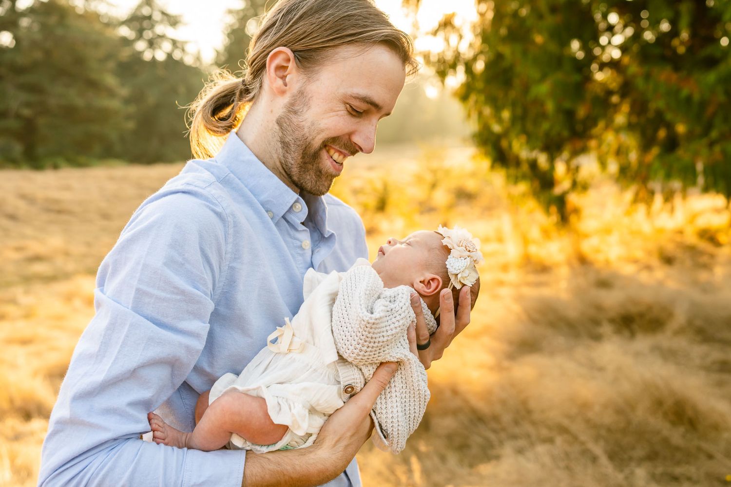 Father smiling at his newborn daughter at Wellington hills at sunset
