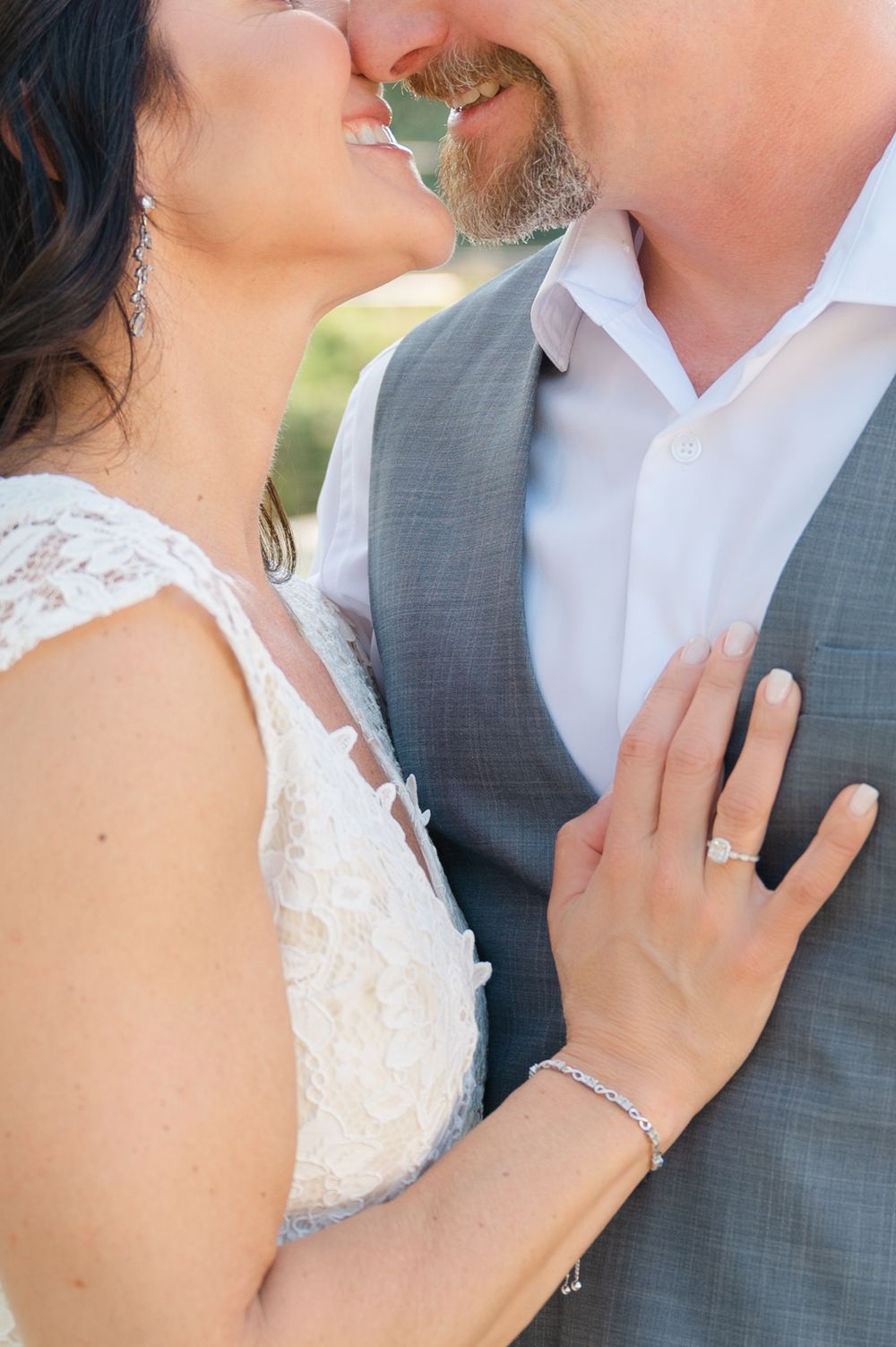 Close-up detail of wedding rings and formal attire during an intimate moment.