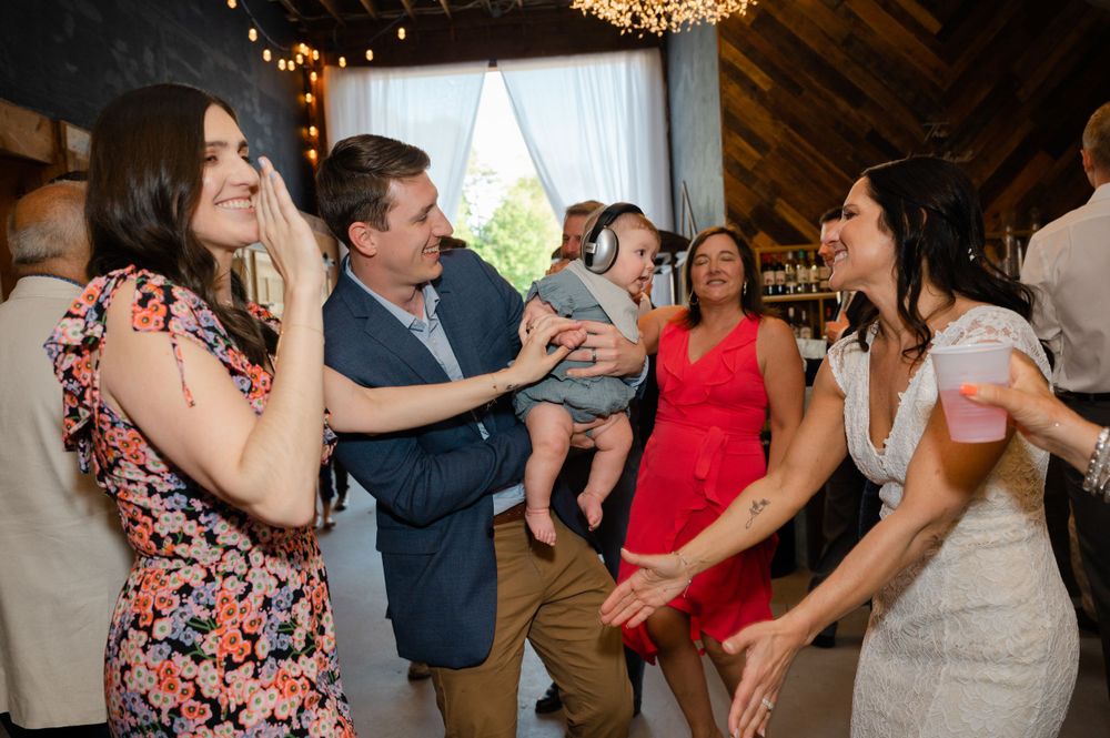 Lively dance party scene at a wedding reception with guests in colorful attire.