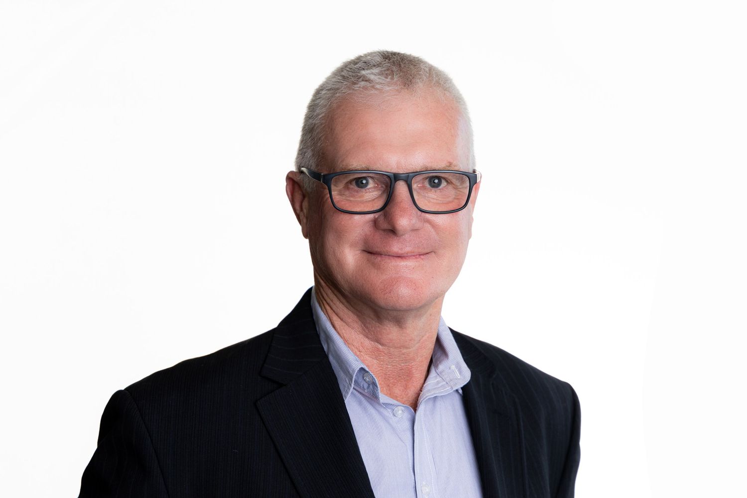 Professional headshot of a person in glasses wearing a dark suit jacket.