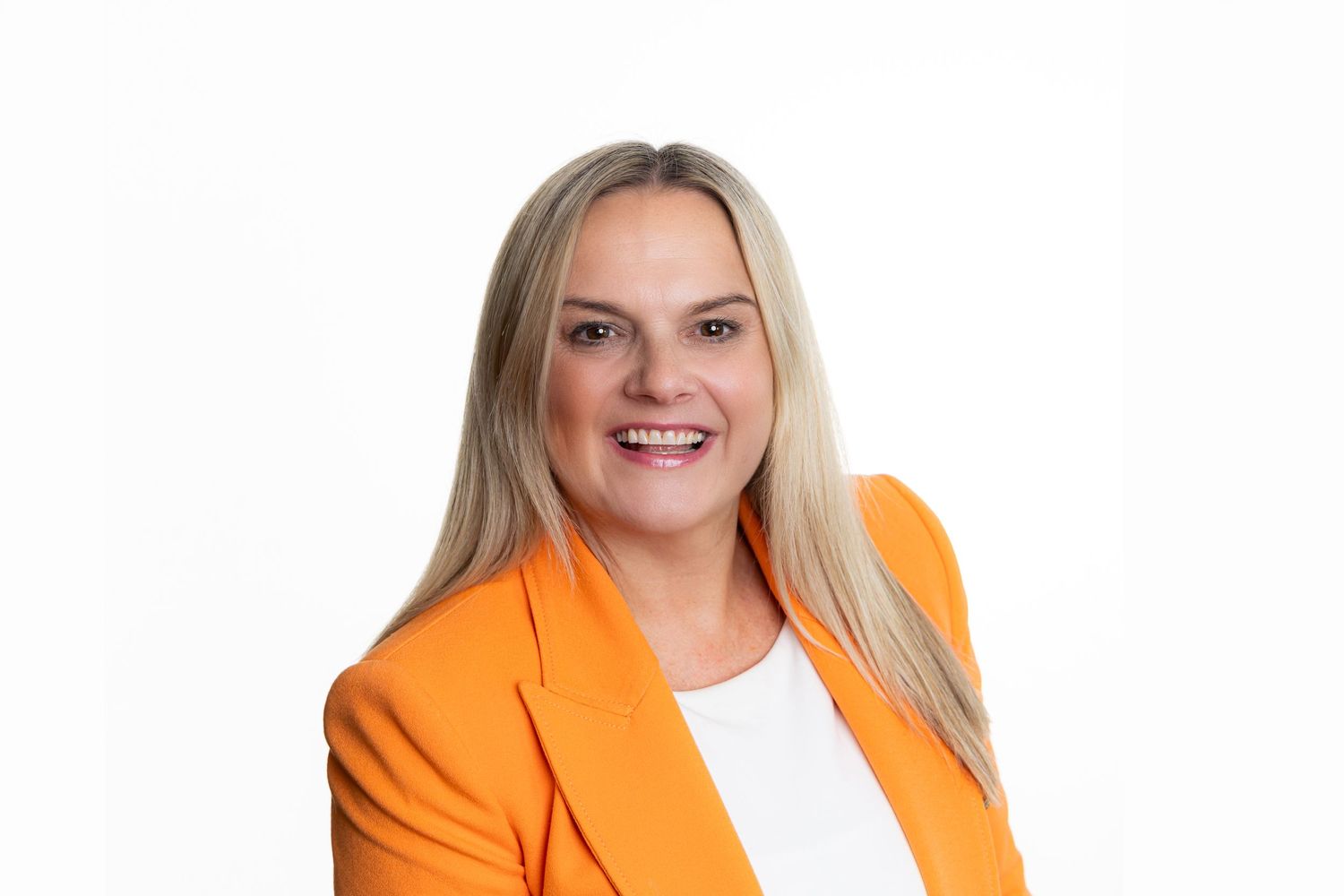 Professional headshot of a person in an orange blazer against a white background.
