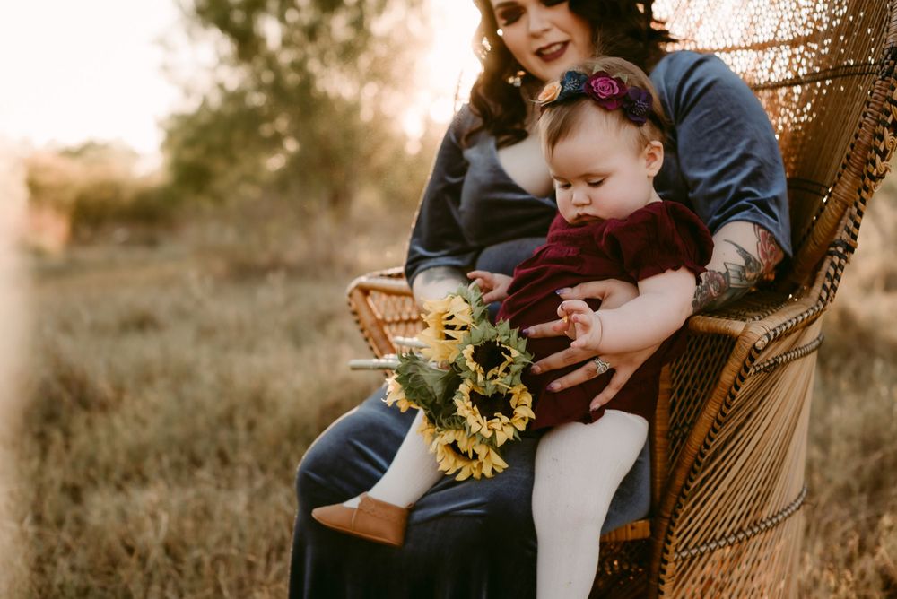A Mom and Daughter Wearing Bold, Velvet Dresses Sitting on a Peacock Chair at Crescent Bend Park in Cibolo, Texas