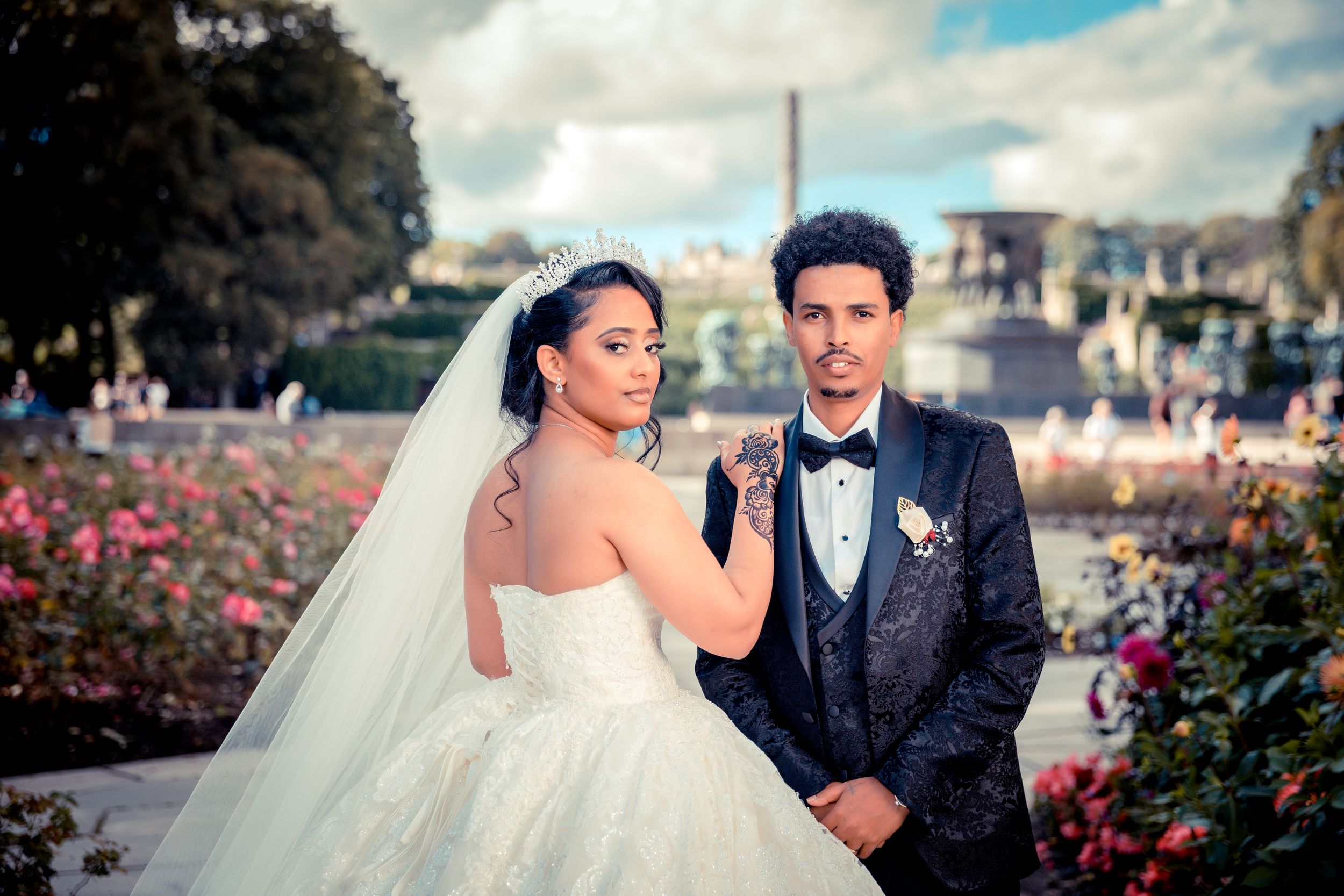 A romantic wedding photo with the Eiffel Tower and pink roses in the background.