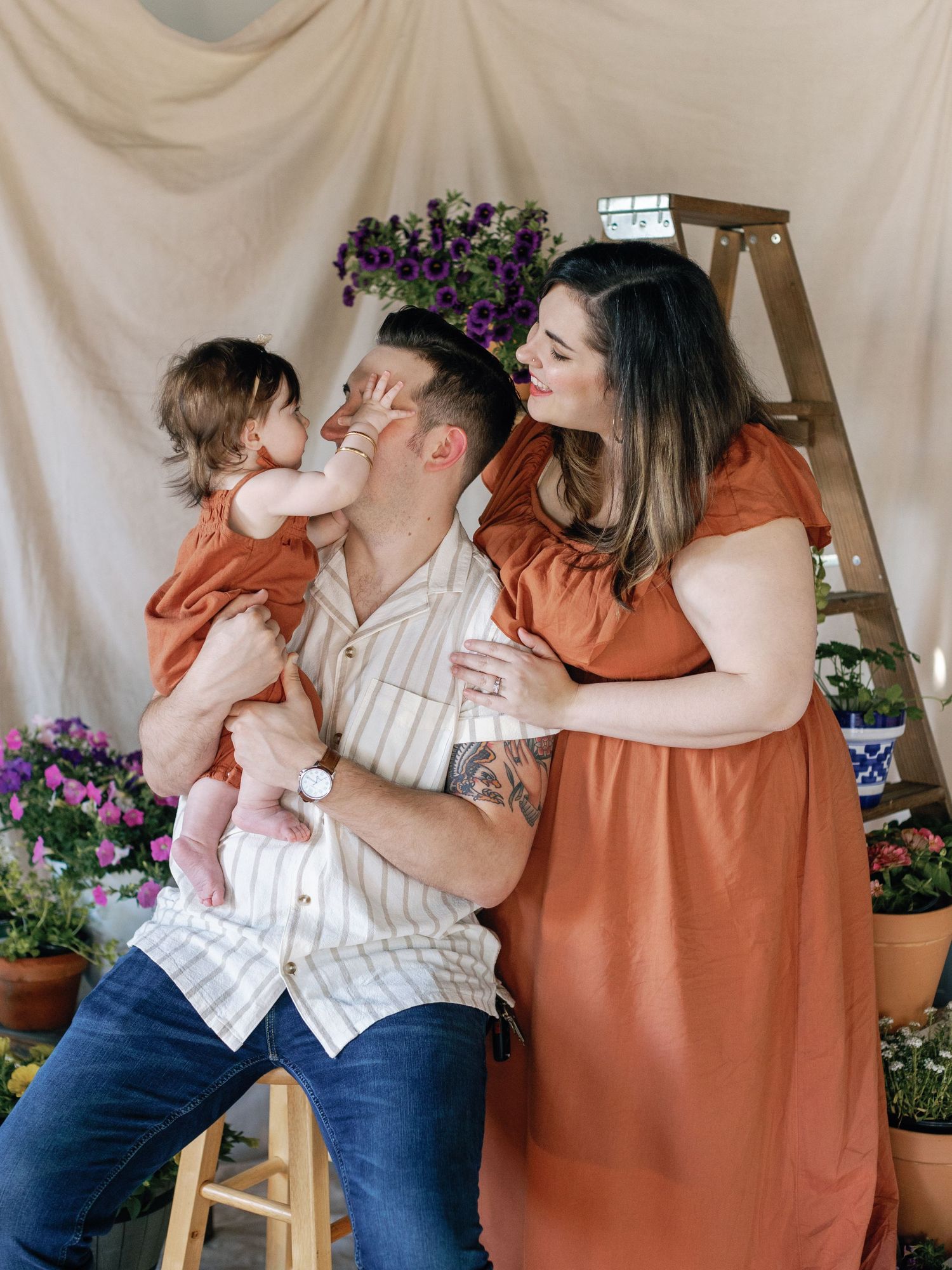 Casual indoor family portrait with floral decor and rustic elements.