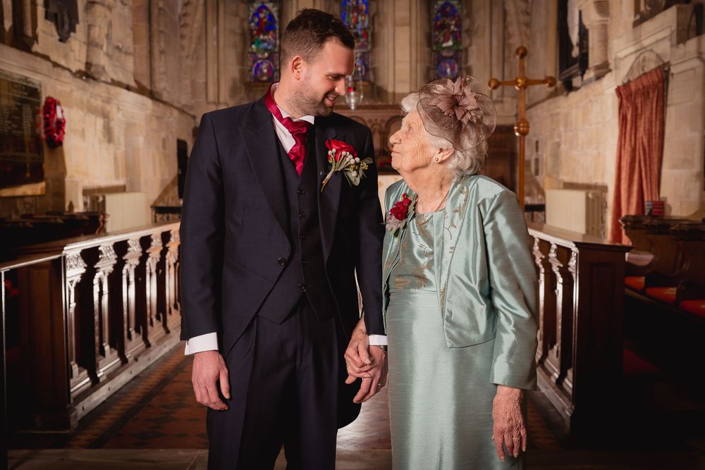 Candid moments captured inside historic church with stained glass windows and stone architecture.