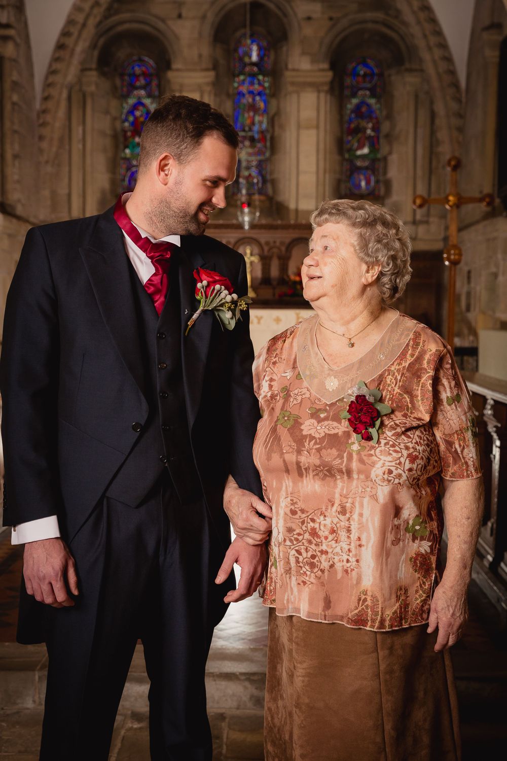 Wedding photos in church with ornate stone archways and stained glass windows in background.
