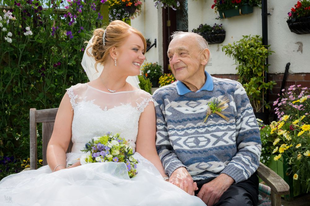 Intimate wedding moments shared between guests in a lush garden setting with flowering plants.
