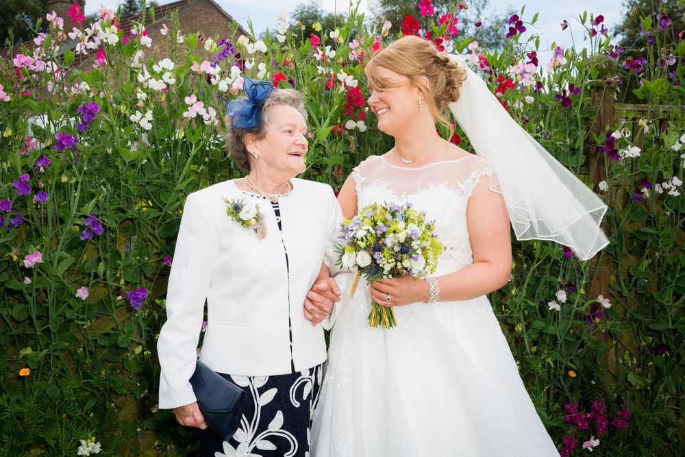 Wedding photos captured in a beautiful garden setting with vibrant purple and pink flowers.