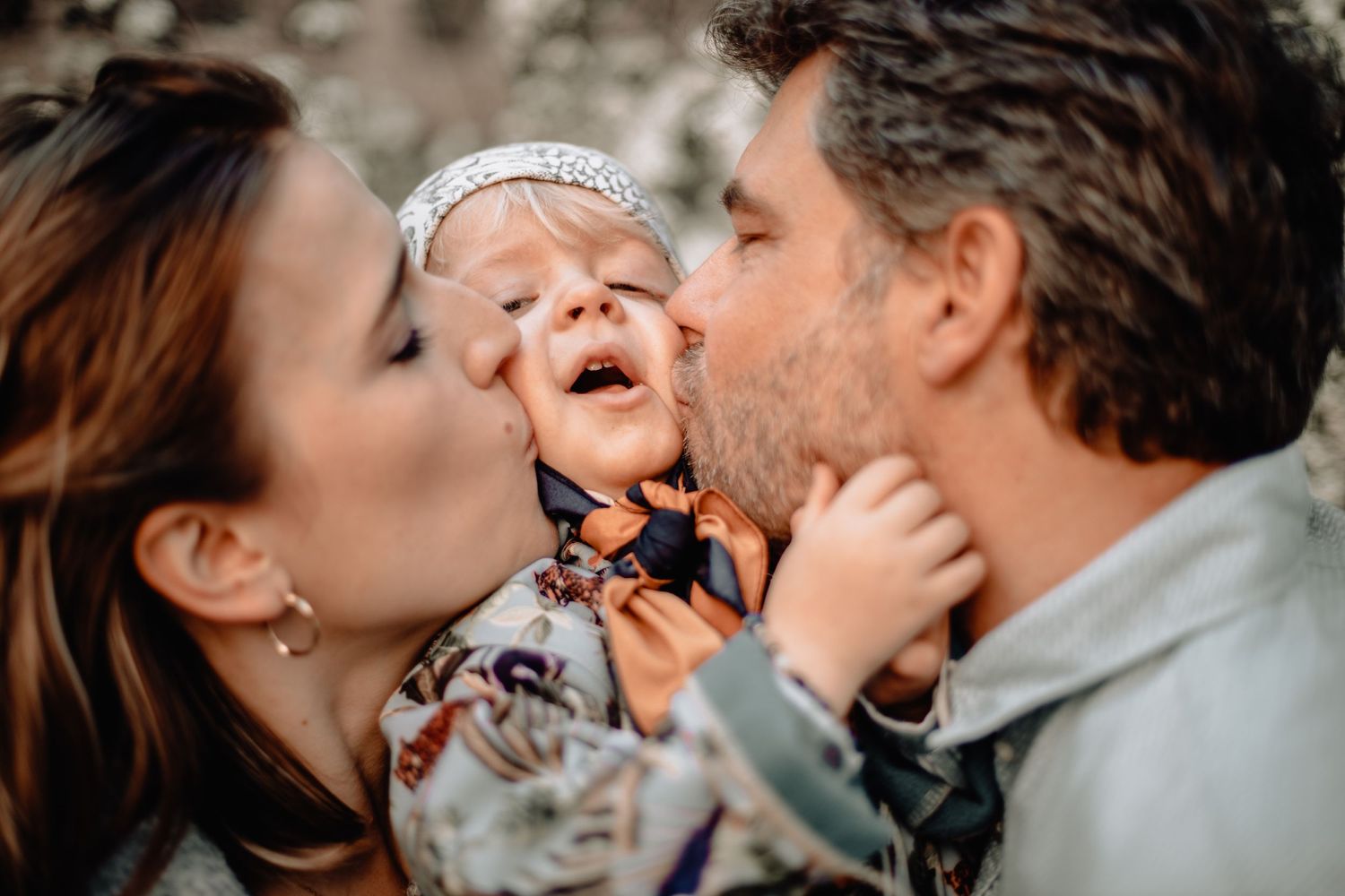 Séance photo famille en extérieur, rires et complicité capturés dans un cadre naturel.