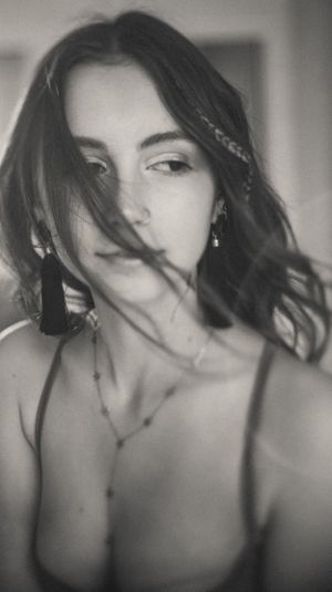 Vintage-style portrait with tassel earrings and delicate braided hair detail.