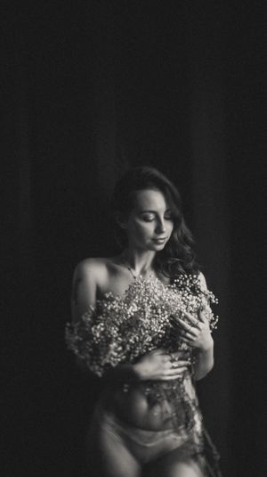 Moody black and white portrait series with delicate white flowers.