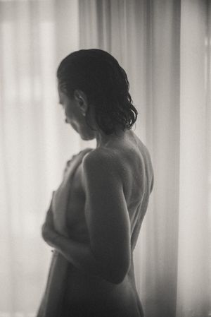 Silhouetted figure in soft backlit window light creating dramatic shadows and shapes.
