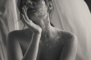 Artistic black and white portrait series showing water droplets and reflective surfaces in moody lighting.