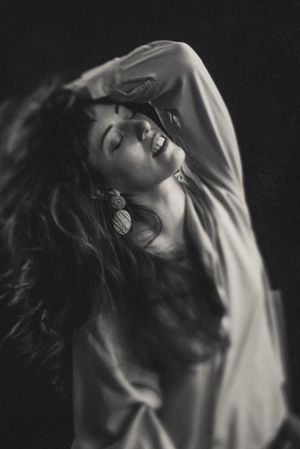 Black and white artistic portrait series showing dramatic poses in low light with moody shadows.