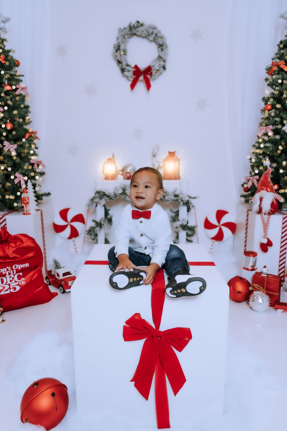 Christmas themed photo setup with peppermint decorations and red bows on white background.