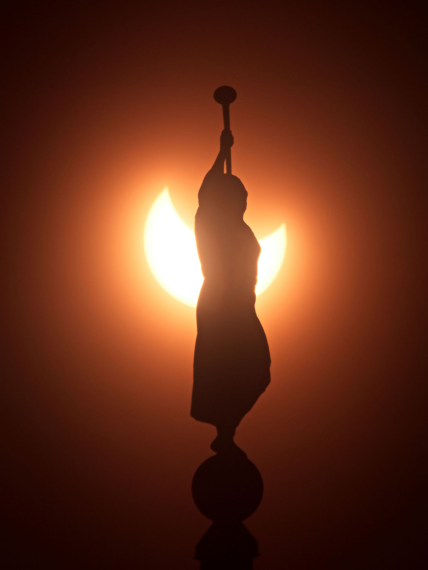 A partial solar eclipse appears to be wings on the Angel Moroni on the Saratoga Springs Temple