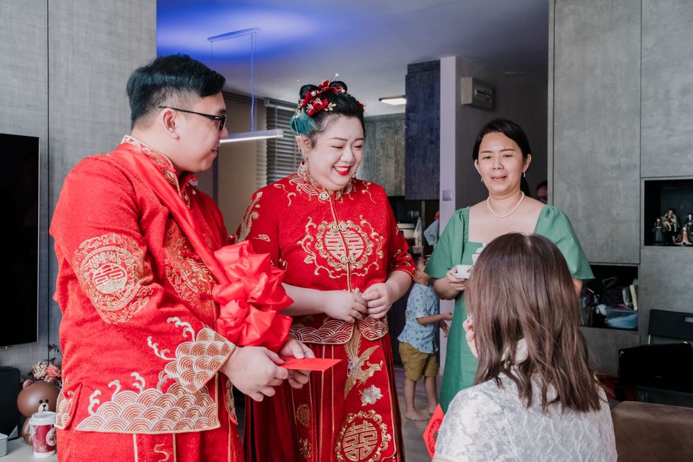 Wedding guests gather in a modern living room wearing traditional Chinese attire.