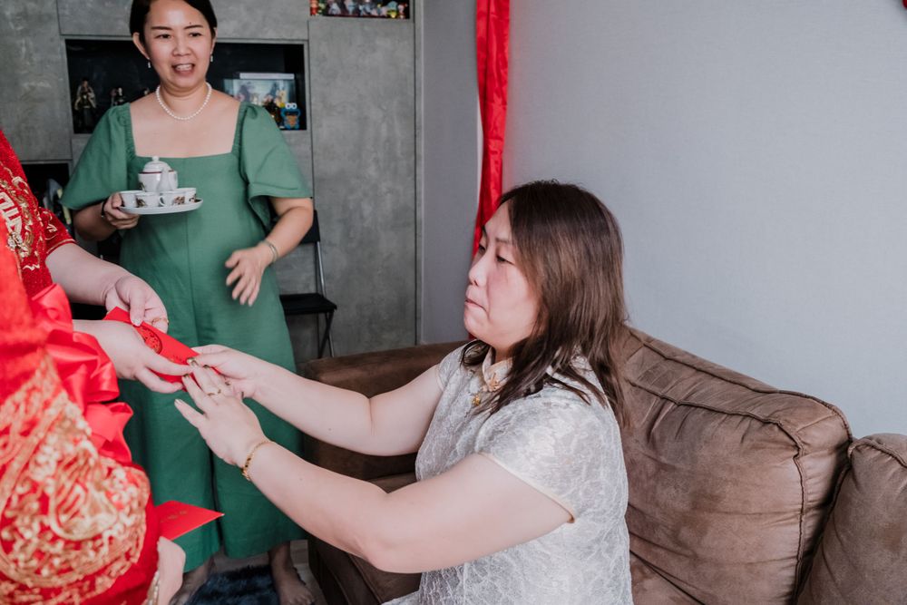 A guest receives a red envelope during a traditional Chinese celebration.
