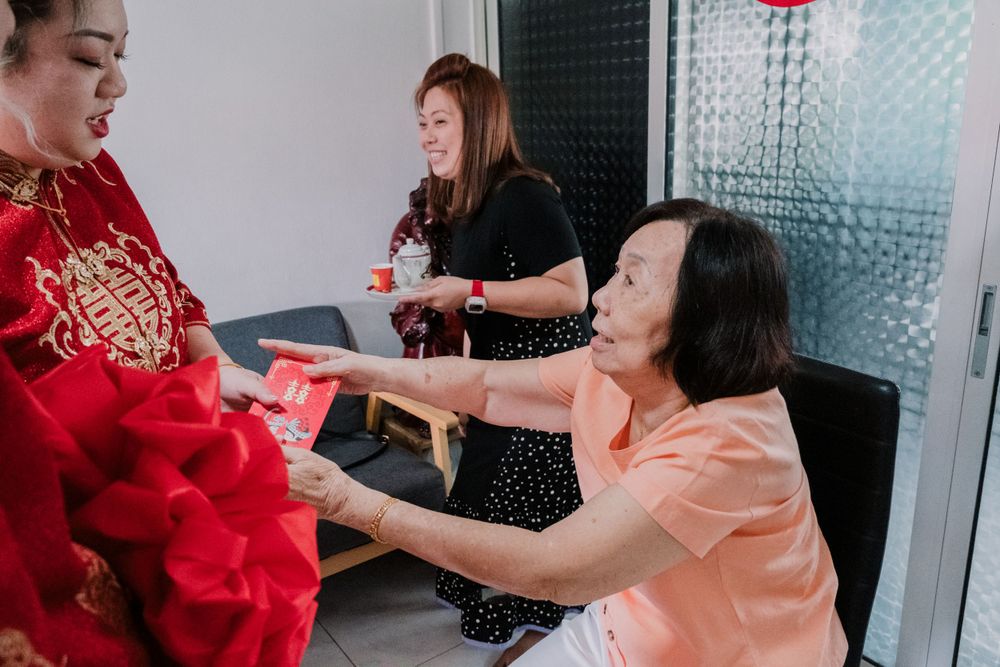 Guests exchange red envelopes during a traditional Chinese celebration.