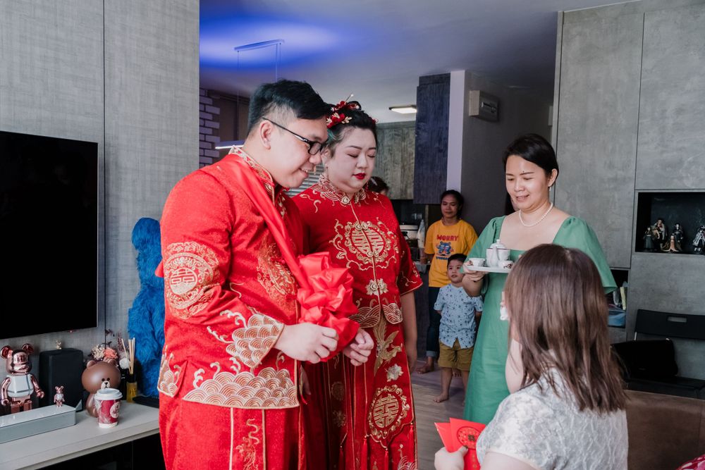 A traditional Chinese wedding ceremony with guests wearing red and gold attire.