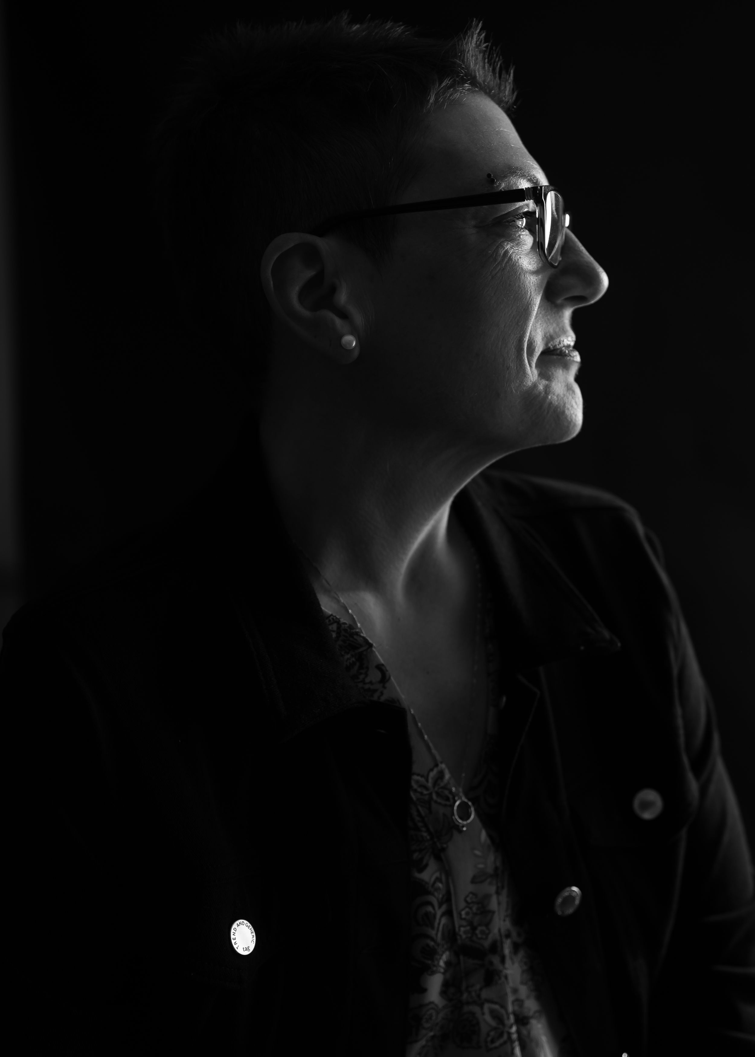 Dramatic black and white profile portrait with dramatic side lighting.