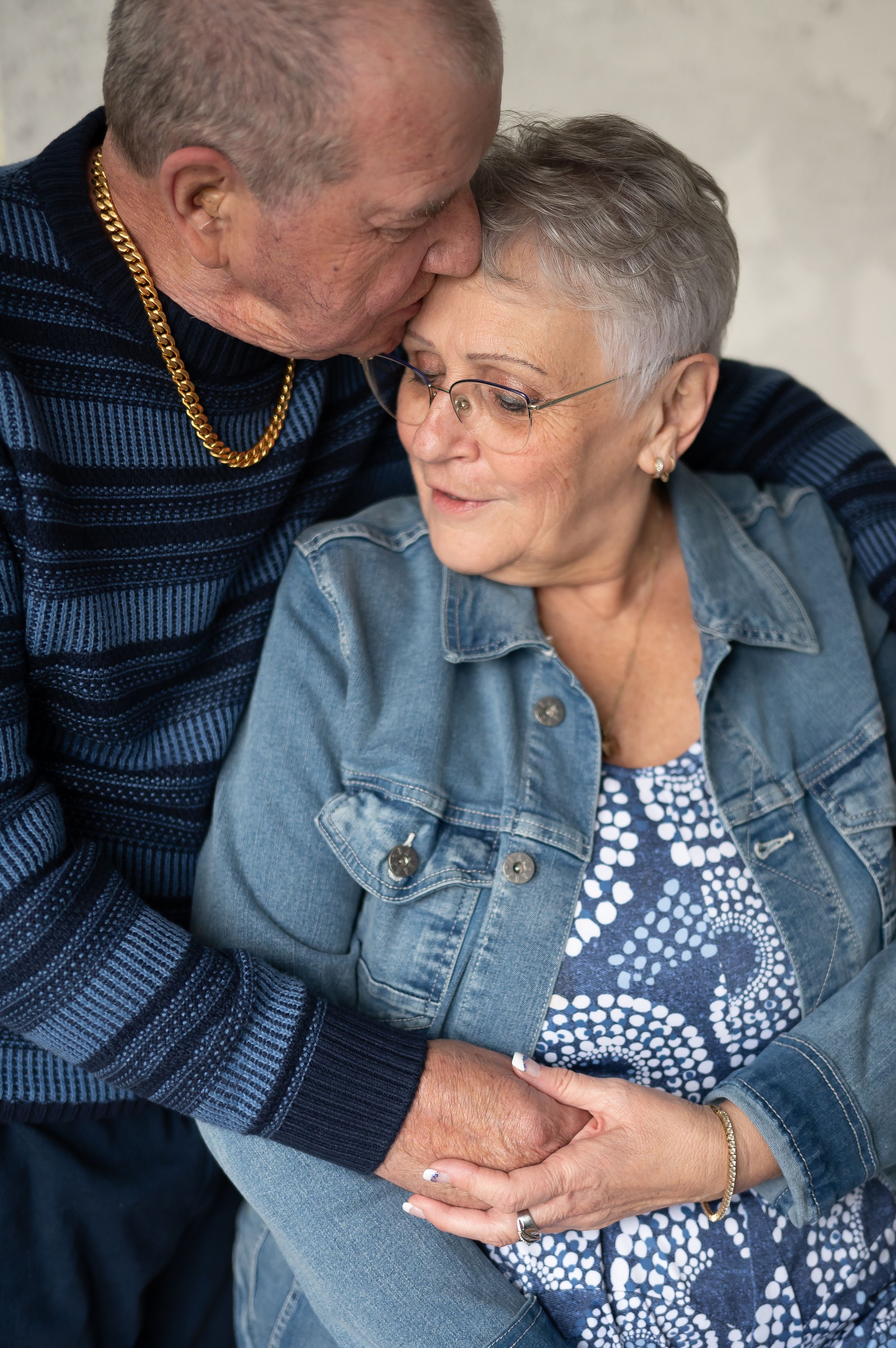 Close-up portrait of a loving couple in casual attire embracing tenderly.