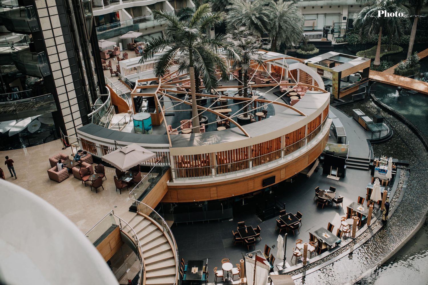 Aerial view of a modern shopping mall interior with curved architecture and multiple levels.