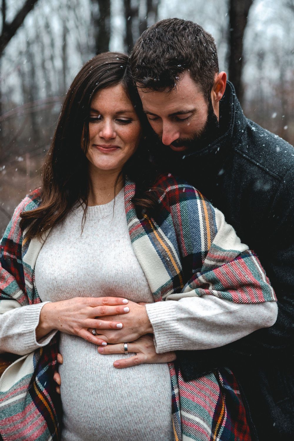 Maternity photos showing couple in cozy knit sweaters during winter.