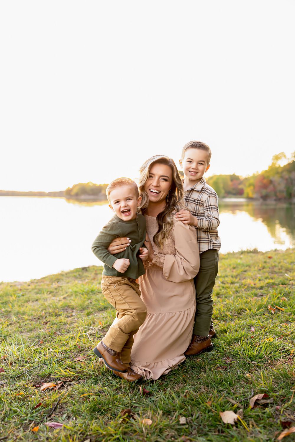 A candid family moment captured by a lake during sunset.