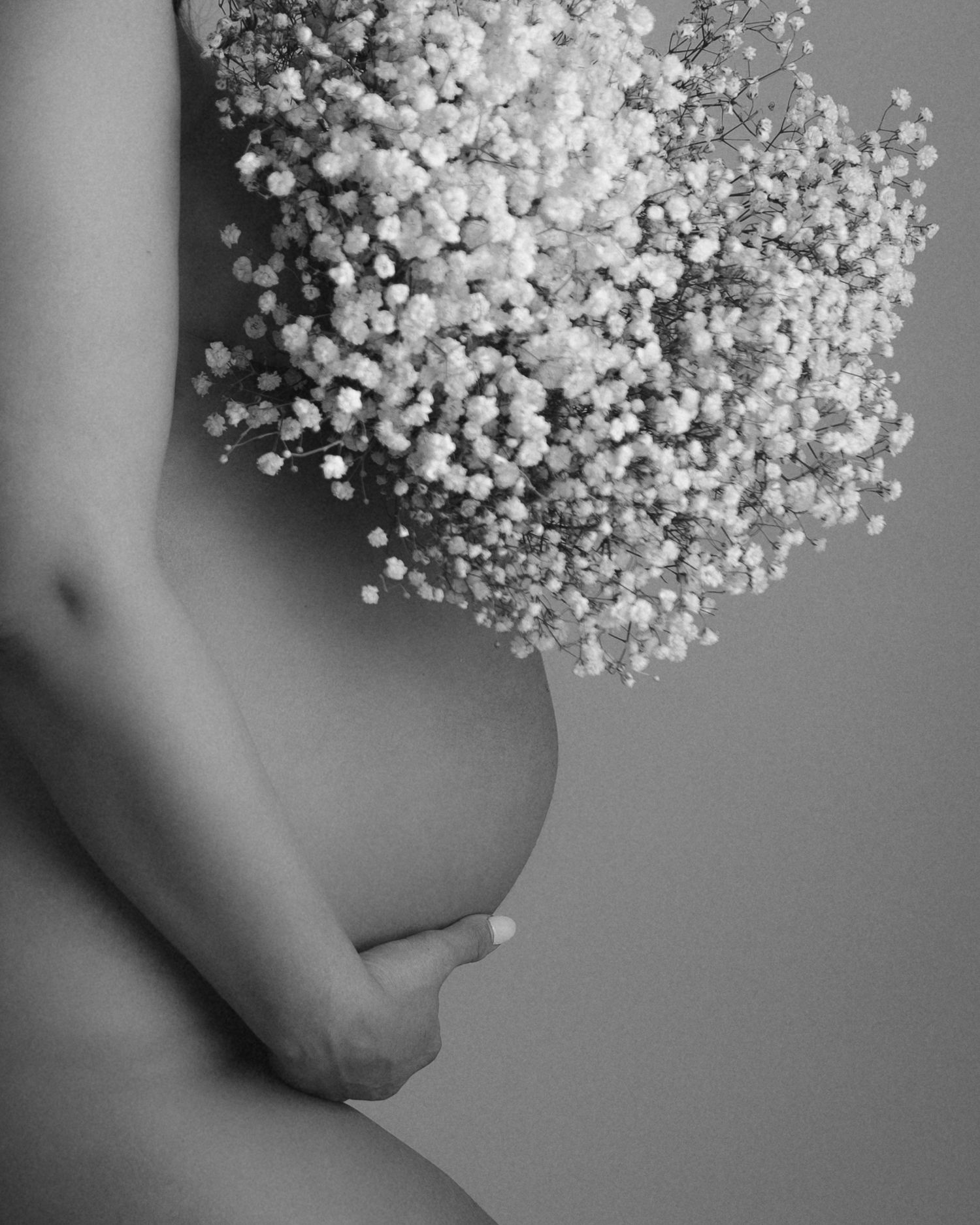 Close-up detail shot of baby's breath flowers creating soft texture against skin.