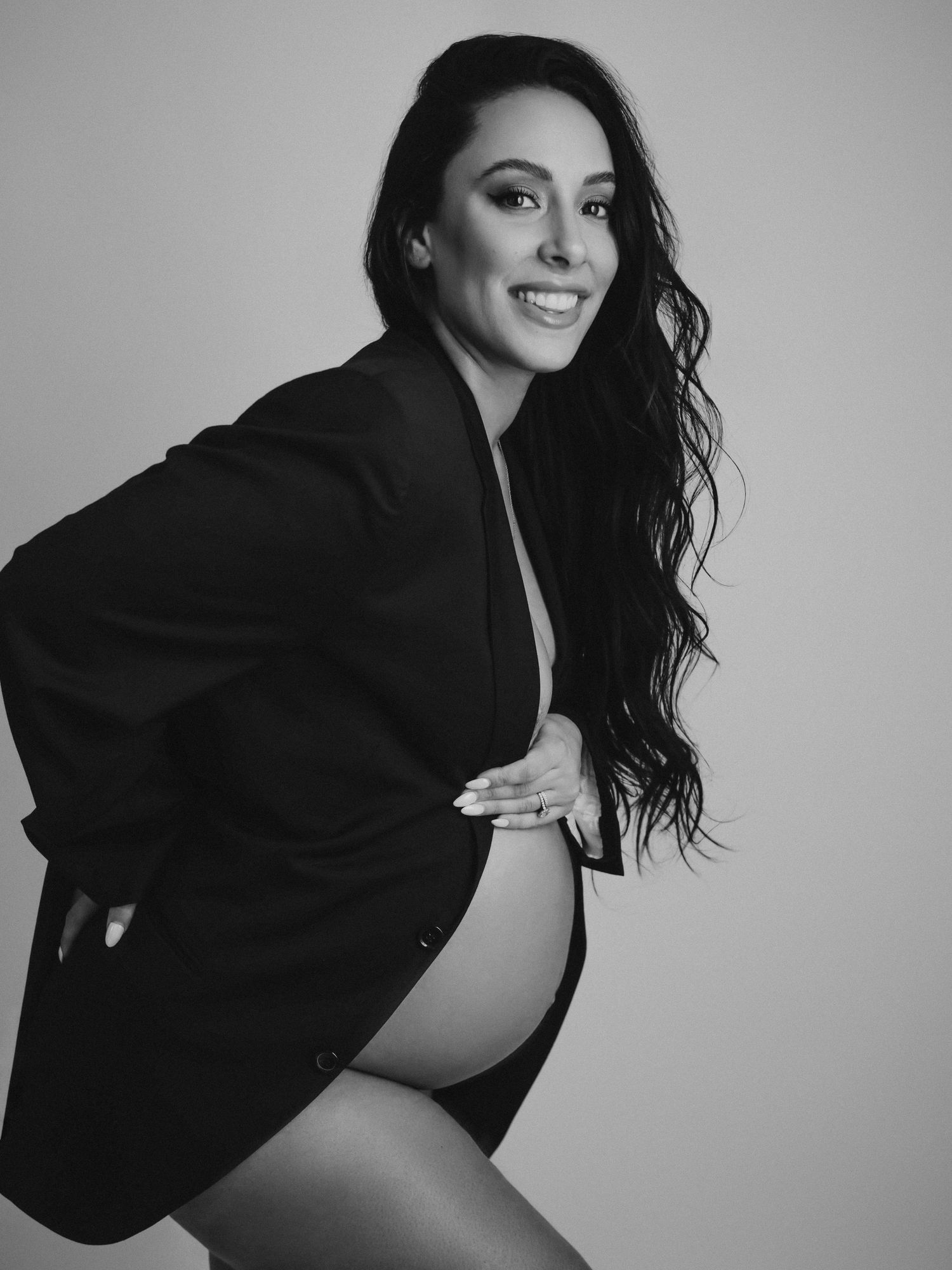 Dynamic black and white maternity photos showing playful movement and expressions.