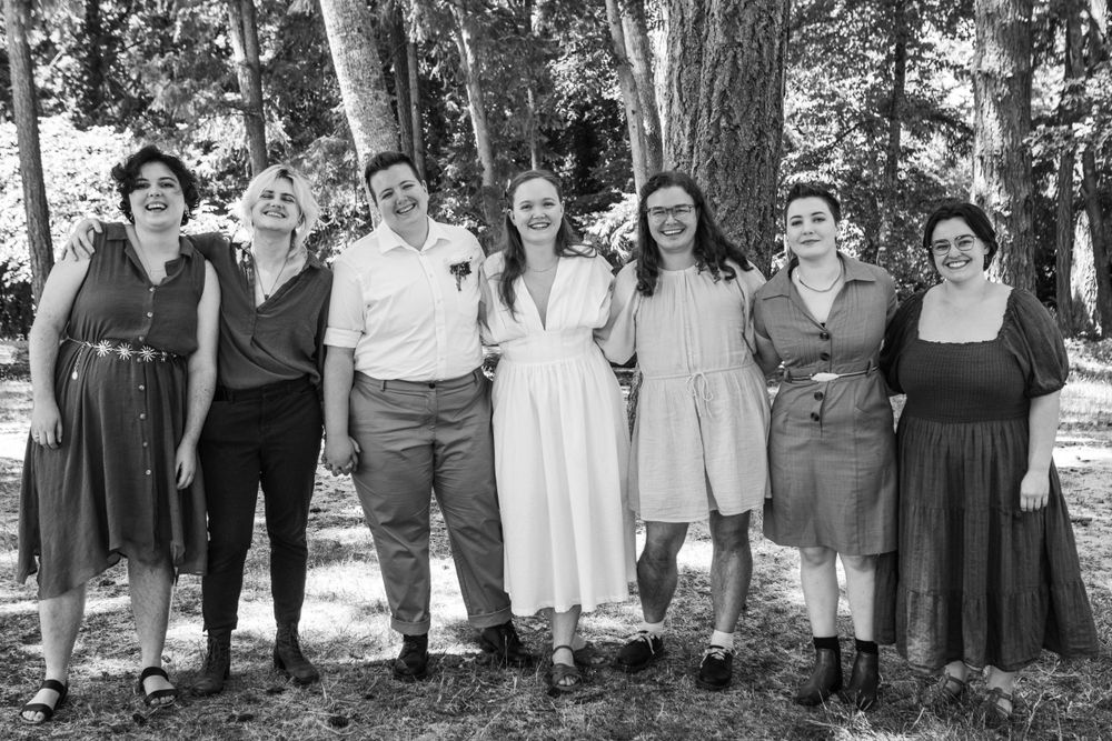 The small wedding party of a beautiful queer wedding, photographed in black and white at a park in Eugene, OR
