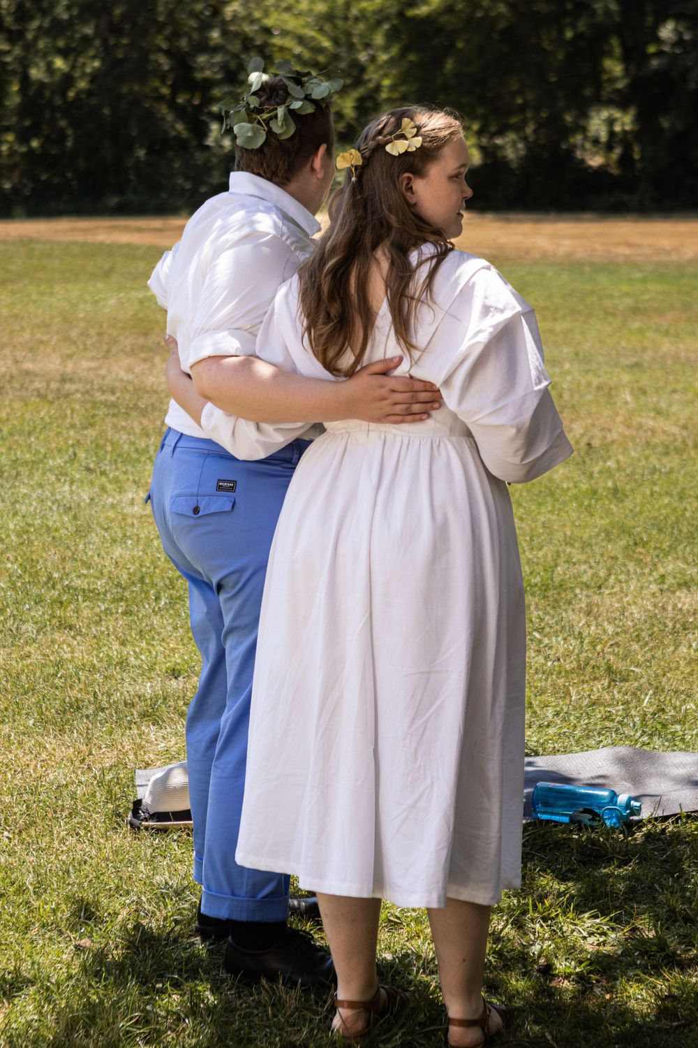 A queer newlywed couple holds one another on their wedding day