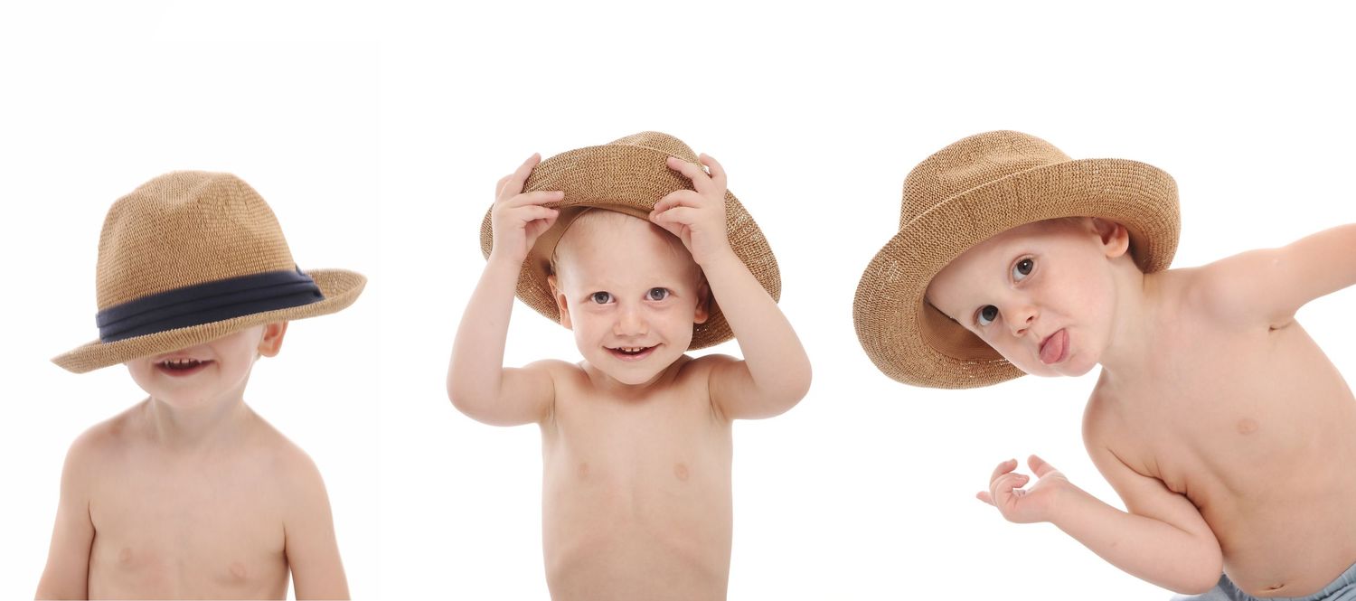 Three toddlers in straw hats making silly expressions.