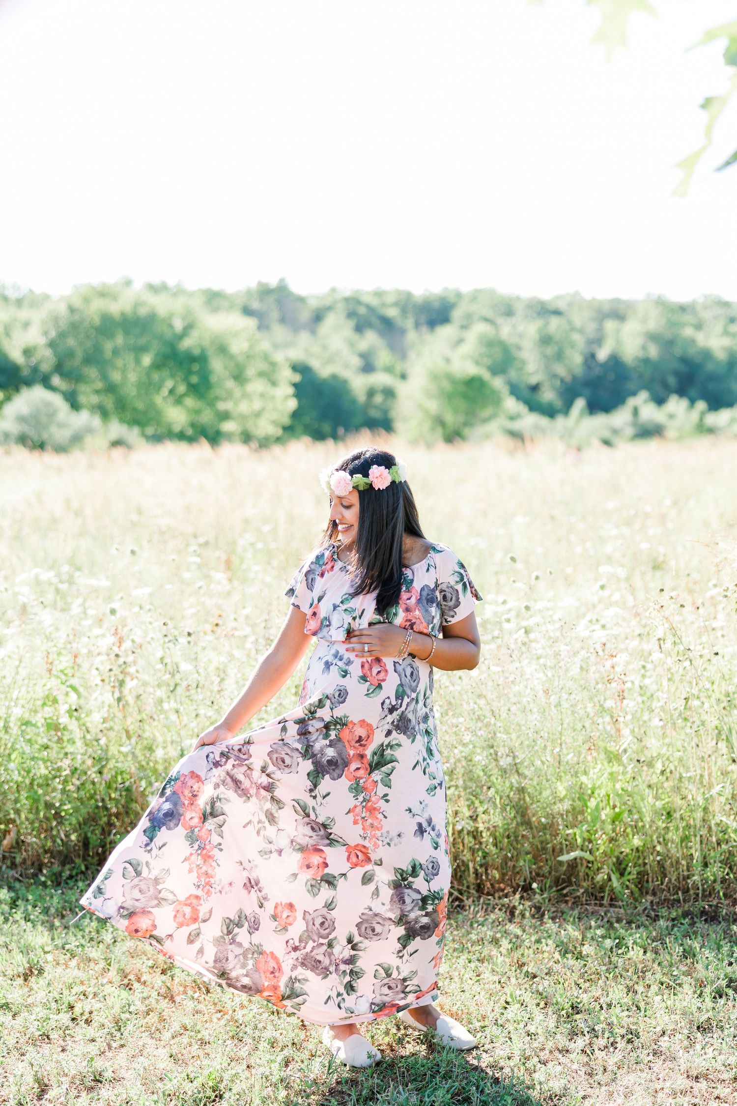 Floral maxi dress flowing in a sunny meadow with wildflowers on a bright summer day.