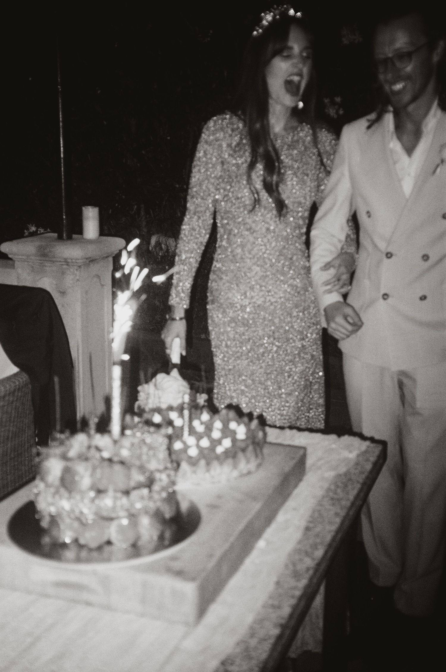 Couple celebrating with wedding cake in black and white vintage style photo.