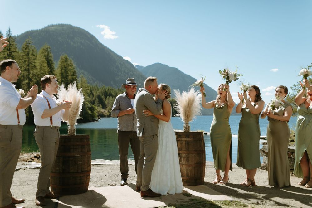 Wedding celebration near wine barrels with mountain vista backdrop.