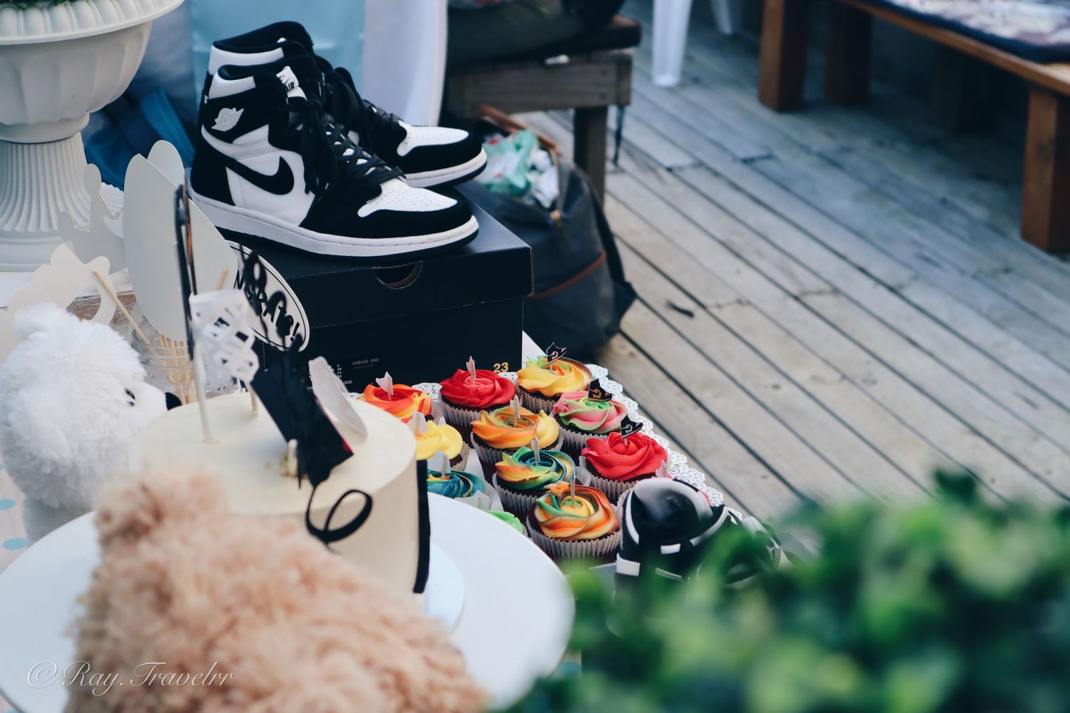 Nike Air Jordan sneakers and colorful shoes arranged on a wooden deck with decorative elements.