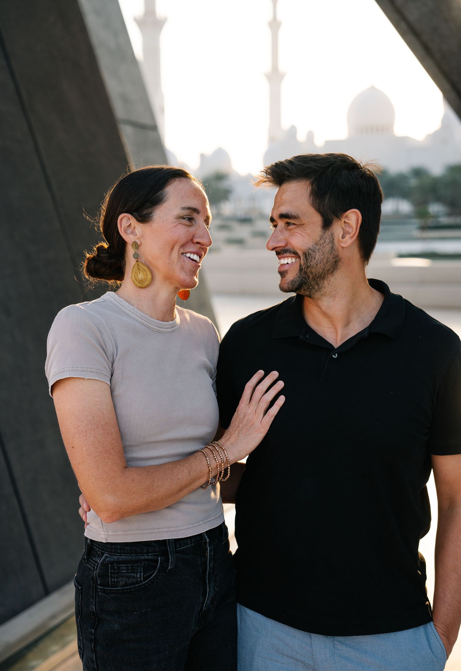 A couple shares a joyful laugh together at the Sheikh Zayed Grand Mosque.