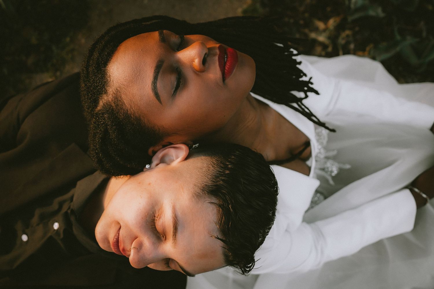 A romantic close-up portrait of a couple lying down together with eyes closed in intimate repose.