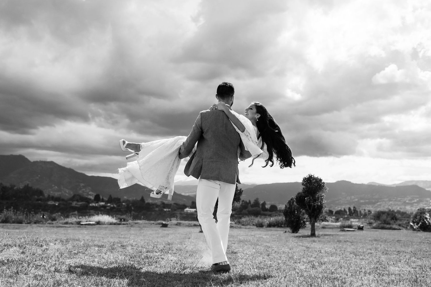 Black and white photo of figures walking across a mountain landscape.
